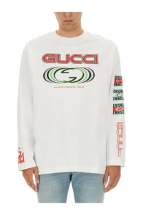 White gucci men’s jersey long-sleeve t-shirt with bold red and green logo graphics on chest and sleeves