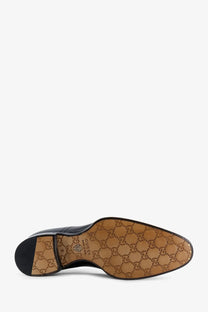 Black Gucci men’s leather dress shoe with tan sole featuring the iconic GG monogram pattern