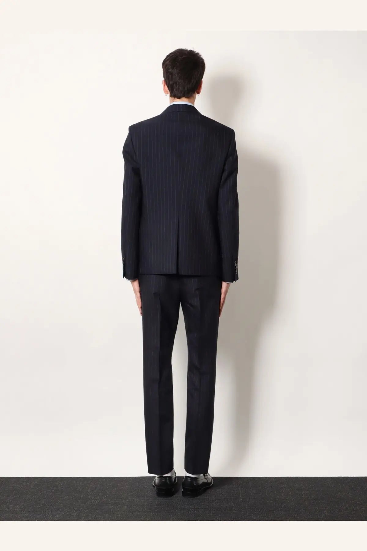 A dark navy pinstripe suit with tailored fit and classic lapel paired with gucci grey wool pinstripe trousers