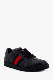 Black Gucci men’s Screener leather sneaker with red and navy stripe and subtle embossed branding on the side