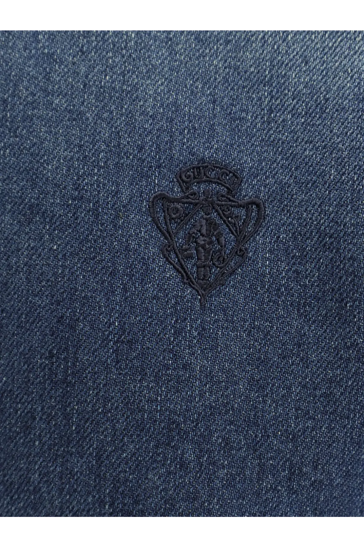 Gucci women’s denim shirt blue with dark blue denim fabric and black embroidered Gucci shield logo on front