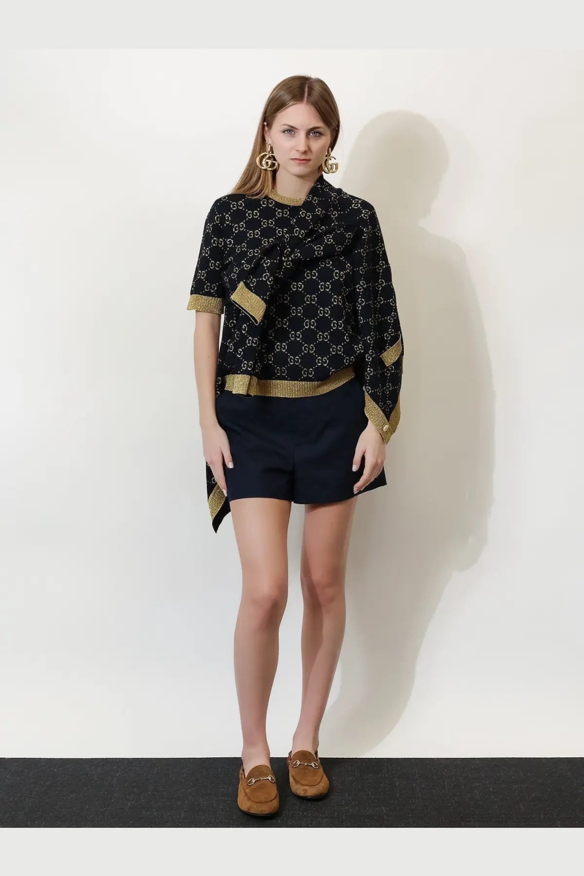 Black gucci women’s cotton blend shorts with gold interlocking g logo pattern and gold-trimmed sleeves with draped neckline