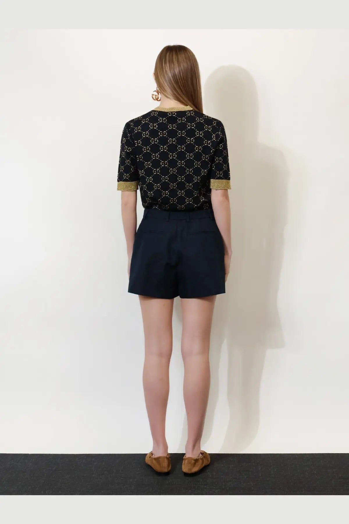 Black gucci cotton blend top with gold toned interlocking gg logo pattern and gold trim on cuffs