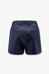 Dark blue gucci women’s gg cotton blend shorts with subtle pattern textured fabric tailored waistband and back pockets back view