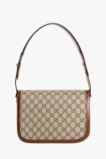 Beige and brown Gucci gg supreme canvas shoulder bag with leather trim in a brown Gucci horsebit crossbody design