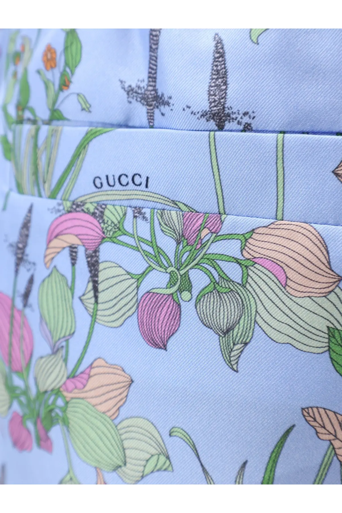 Light blue gucci handbag with delicate pink peach and green botanical print paired with gucci women’s printed silk shorts white