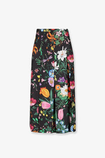 Gucci women’s black silk midi skirt with pleats and vibrant floral and insect print on a dark background
