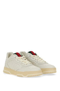 Cream-colored Gucci women’s sneaker with sleek leather upper red and green striped tongue tab and matching rubber sole