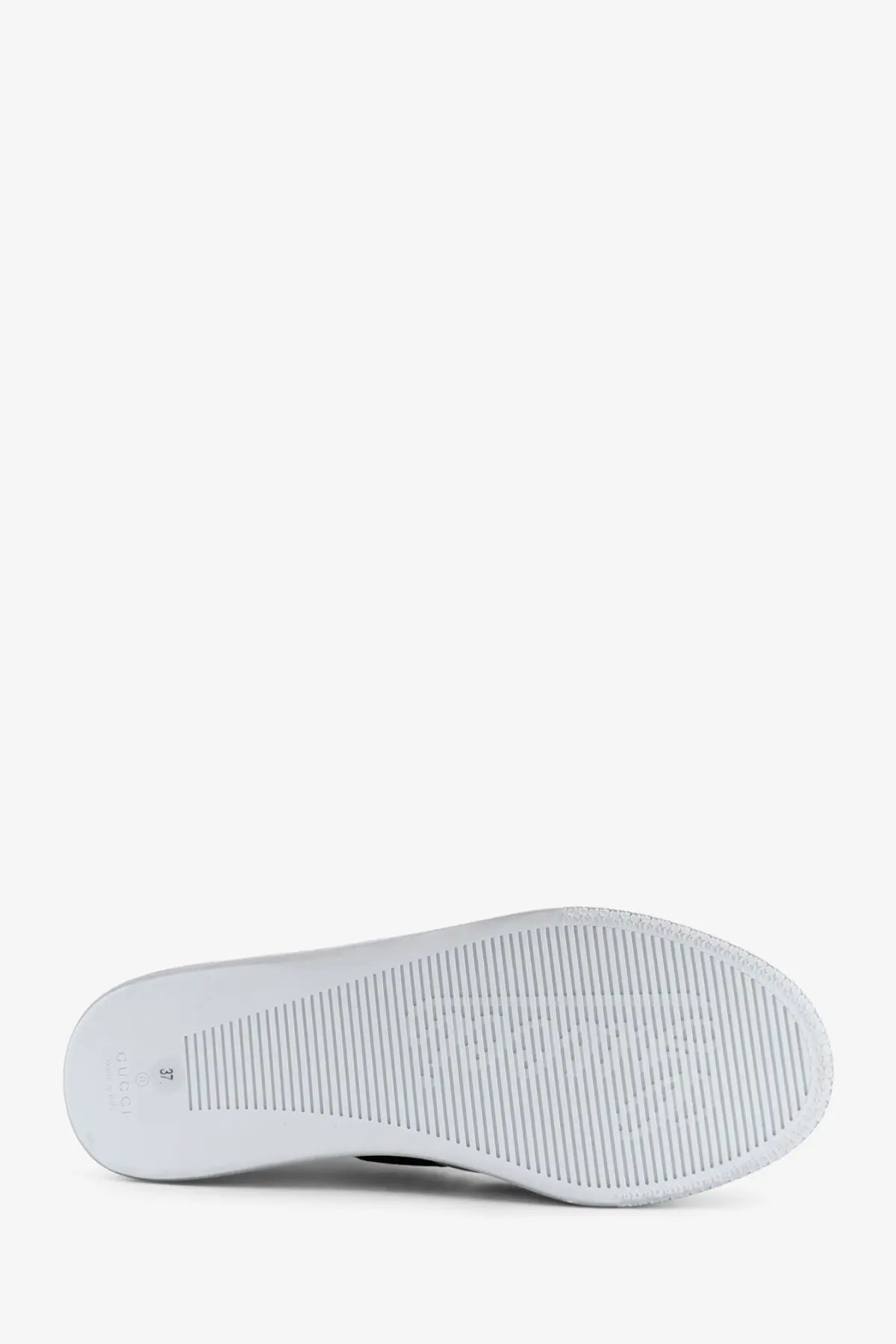 Back side of gucci women’s stretch leather sneakers white showing white rubber sole with textured ribbed pattern and embossed logo