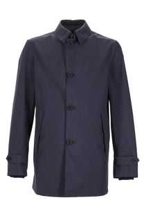 Dark navy blue waterproof trench coat by herno with classic collar button closures and adjustable cuffs