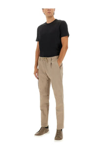 Beige chino trousers with drawstring waistband and subtle pleats paired with herno men’s black cotton shirt