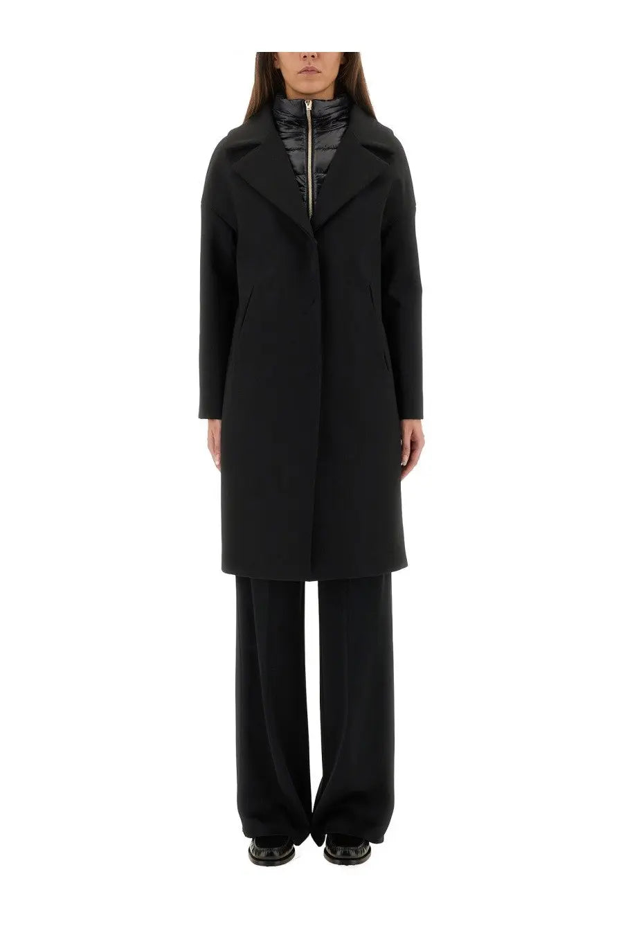 Herno women’s black wool coat with structured collar and front zipper worn over a quilted inner layer