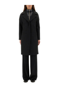 Herno women’s black wool coat with structured collar and front zipper worn over a quilted inner layer