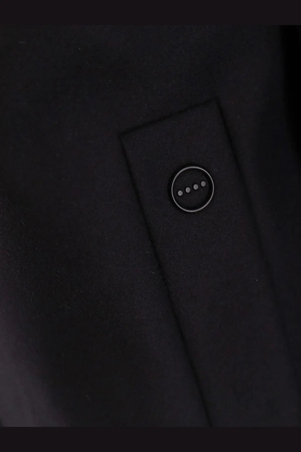 Black hevò men’s loco virgin wool coat button with four silver dots on dark wool fabric close-up view