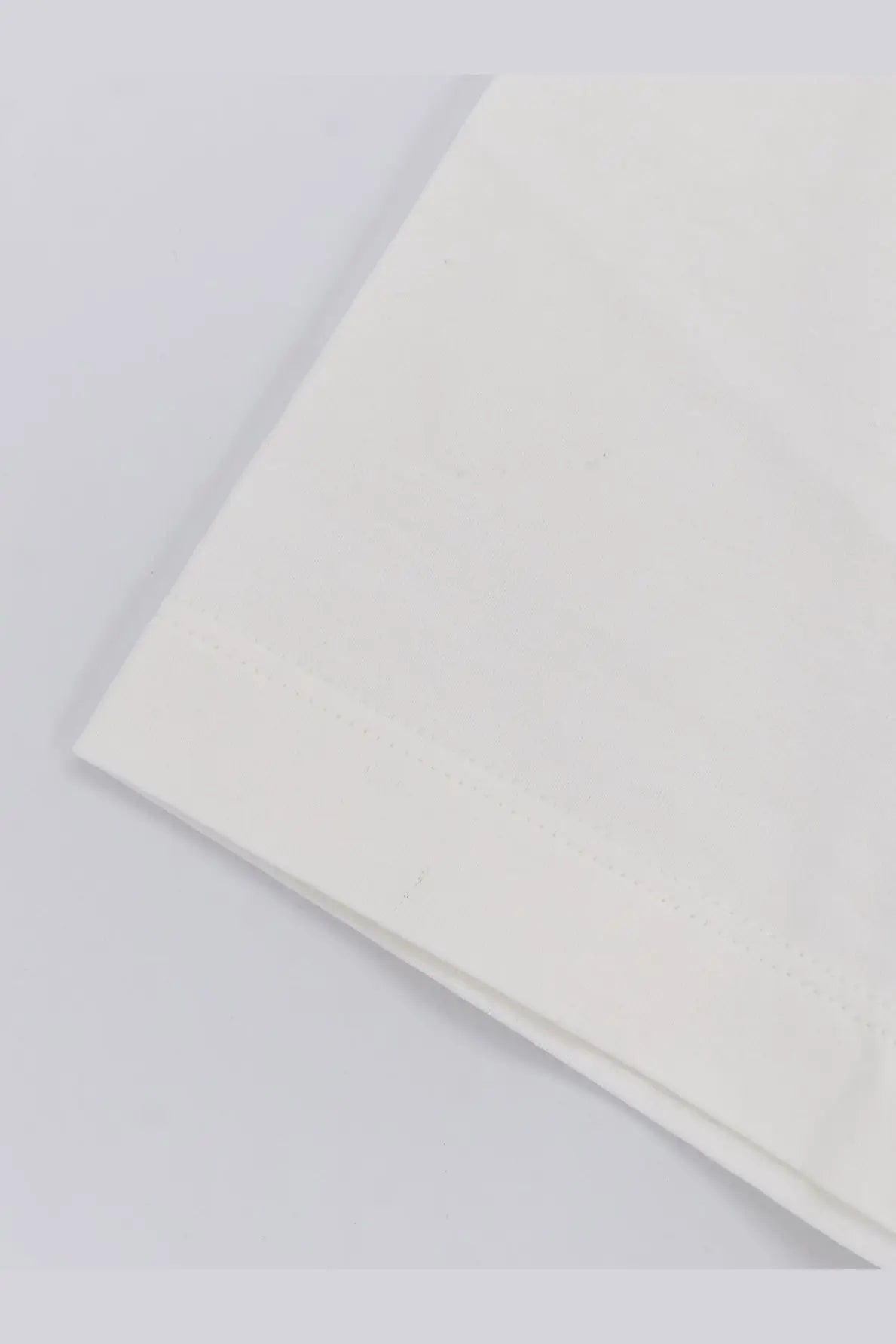 A crisp white hevo men’s mulino cotton shirt with a subtle texture and neatly folded edge pillowcase detail