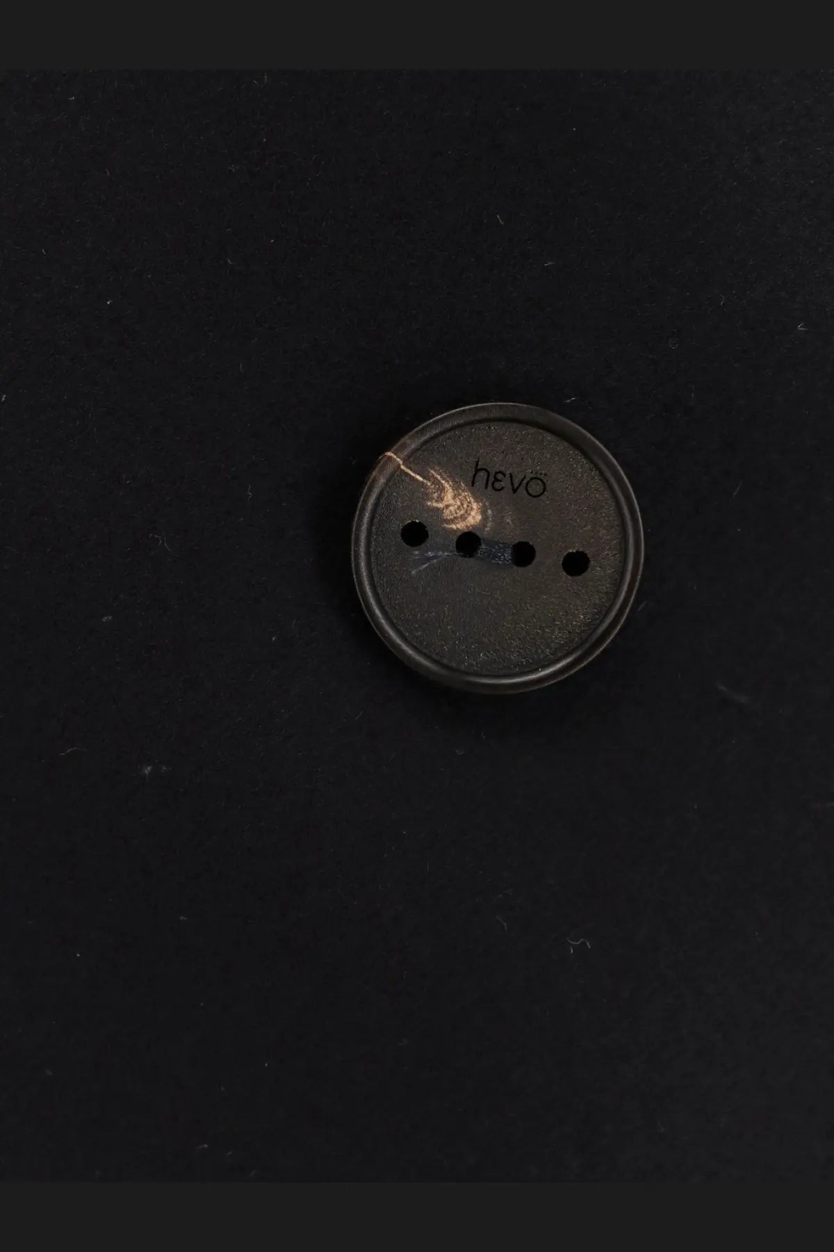 Dark gray circular hevo button with four holes on the hevò men’s trani double breasted blue wool blend coat
