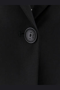 A sleek matte black button with a silver rim on hevò womens frigole virgin sheeps wool black suit