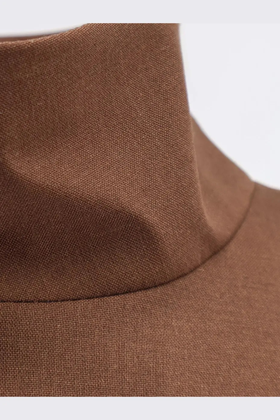 A close-up of a brown finely woven wool blend turtleneck collar on hevò womens porto selvaggio jacket