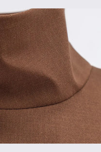 A close-up of a brown finely woven wool blend turtleneck collar on hevò womens porto selvaggio jacket