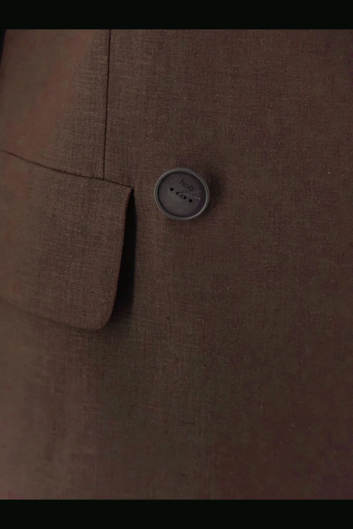 A round gray button with a subtle textured surface and three holes on the hevò women’s rocchetta linen and viscose suit brown