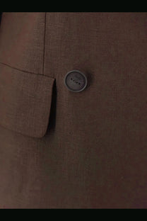 A round gray button with a subtle textured surface and three holes on the hevò women’s rocchetta linen and viscose suit brown