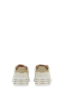 Cream-colored suede hogan women’s rebel sneaker with white rubber sole and gold metallic stripes