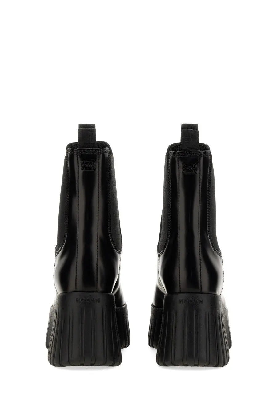 Back view of Hogan women’s black patent leather chelsea boot with chunky ribbed sole and embossed brand name on heel
