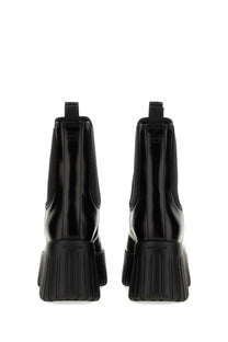Back view of Hogan women’s black patent leather chelsea boot with chunky ribbed sole and embossed brand name on heel