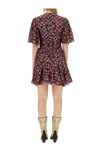 A woman wears an Isabel Marant women’s Lienne dress with puff sleeves and a pink black and white geometric pattern