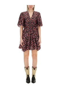 A woman wears an Isabel Marant women’s Lienne dress featuring a short ruched design with pink and black geometric pattern