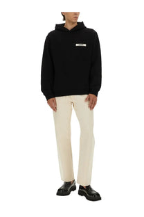 Jacquemus men’s black hooded sweatshirt made of felpa with a white rectangular logo patch on the chest