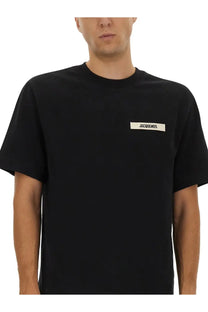 Jacquemus men’s black t-shirt featuring a minimalist white rectangular label on the left chest made with gros grain