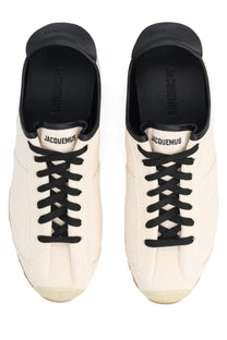 Cream-colored jacquemus men sneaker les tennis white canvas with black laces and rubber toe caps visible from the front