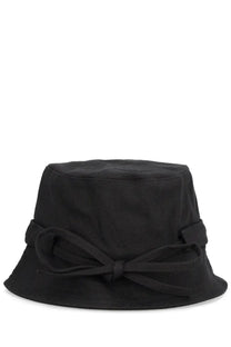 Black bucket hat with a fabric bow tied around the base of the crown.