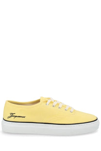 Jacquemus women’s yellow canvas low-top sneaker with white laces black stitching and jacquemus logo embroidery