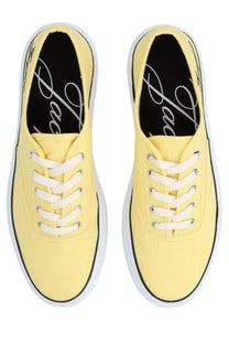 Pair of jacquemus women’s pale yellow canvas sneakers with white laces and black trim for casual wear