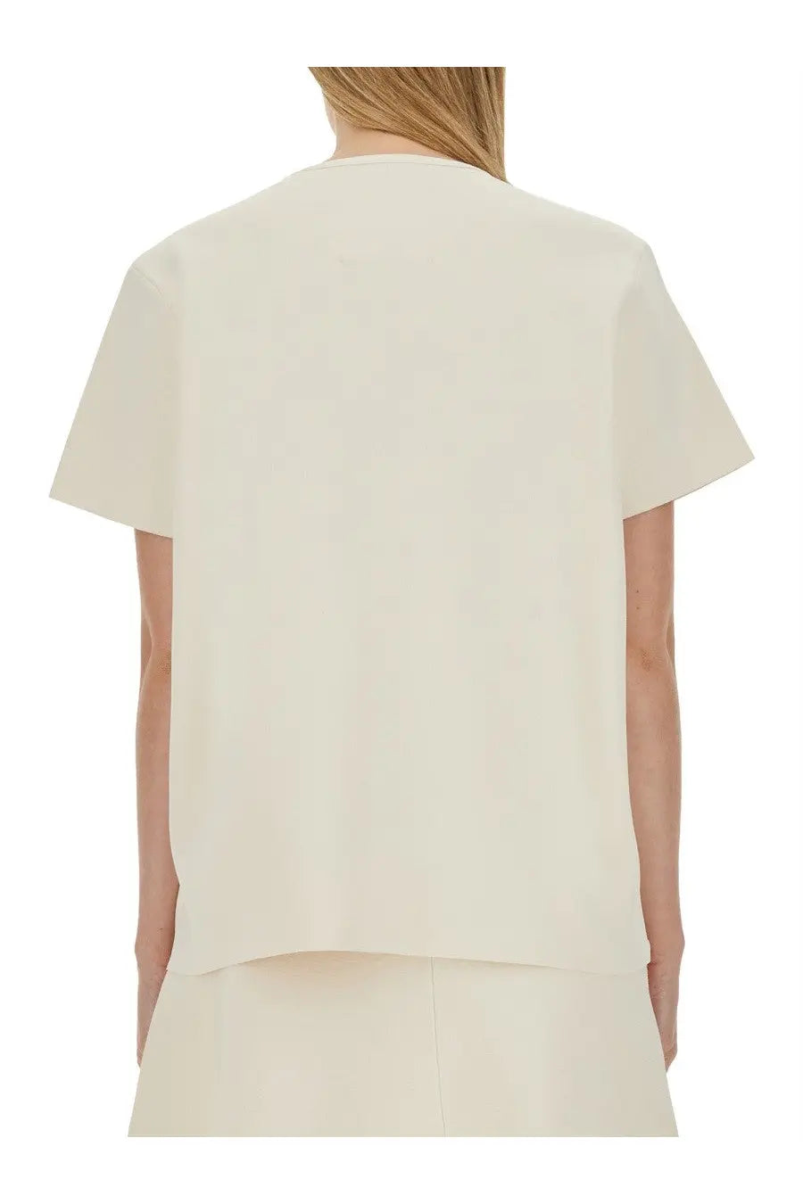 Cream-colored jil sander women’s boxy fit shirt with minimalist short sleeves and subtle asymmetrical hemline