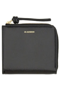 Black jil sander women’s leather card holder with zippered wallet, gold-tone branding, and matching leather pull tab