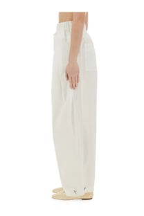 Cream-colored jil sander women’s wide pants in cotton gabardine with relaxed fit elastic waistband and buttoned cuffs