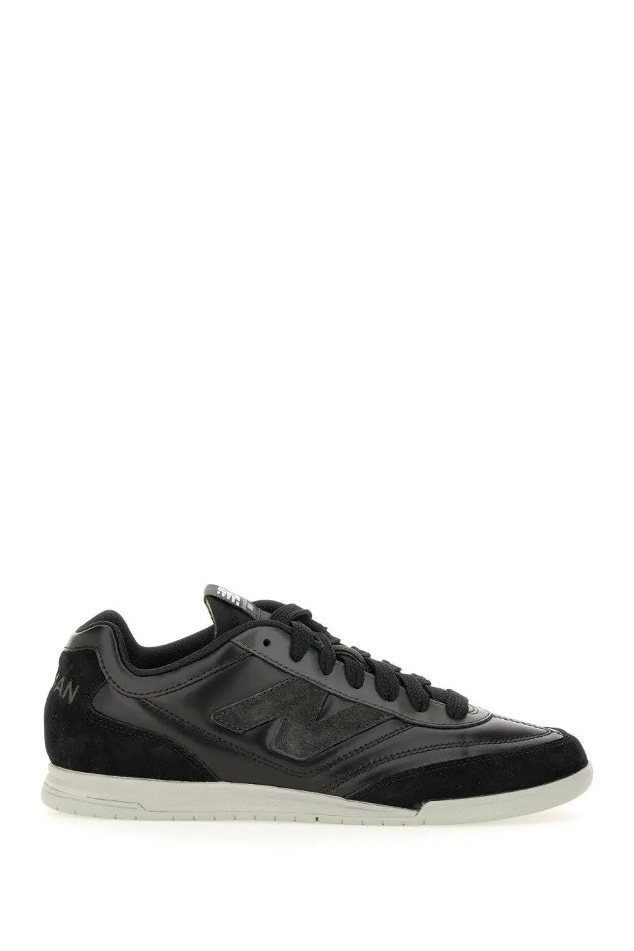 Black new balance sneaker with glossy leather upper suede accents and white rubber sole from Junya Watanabe Man