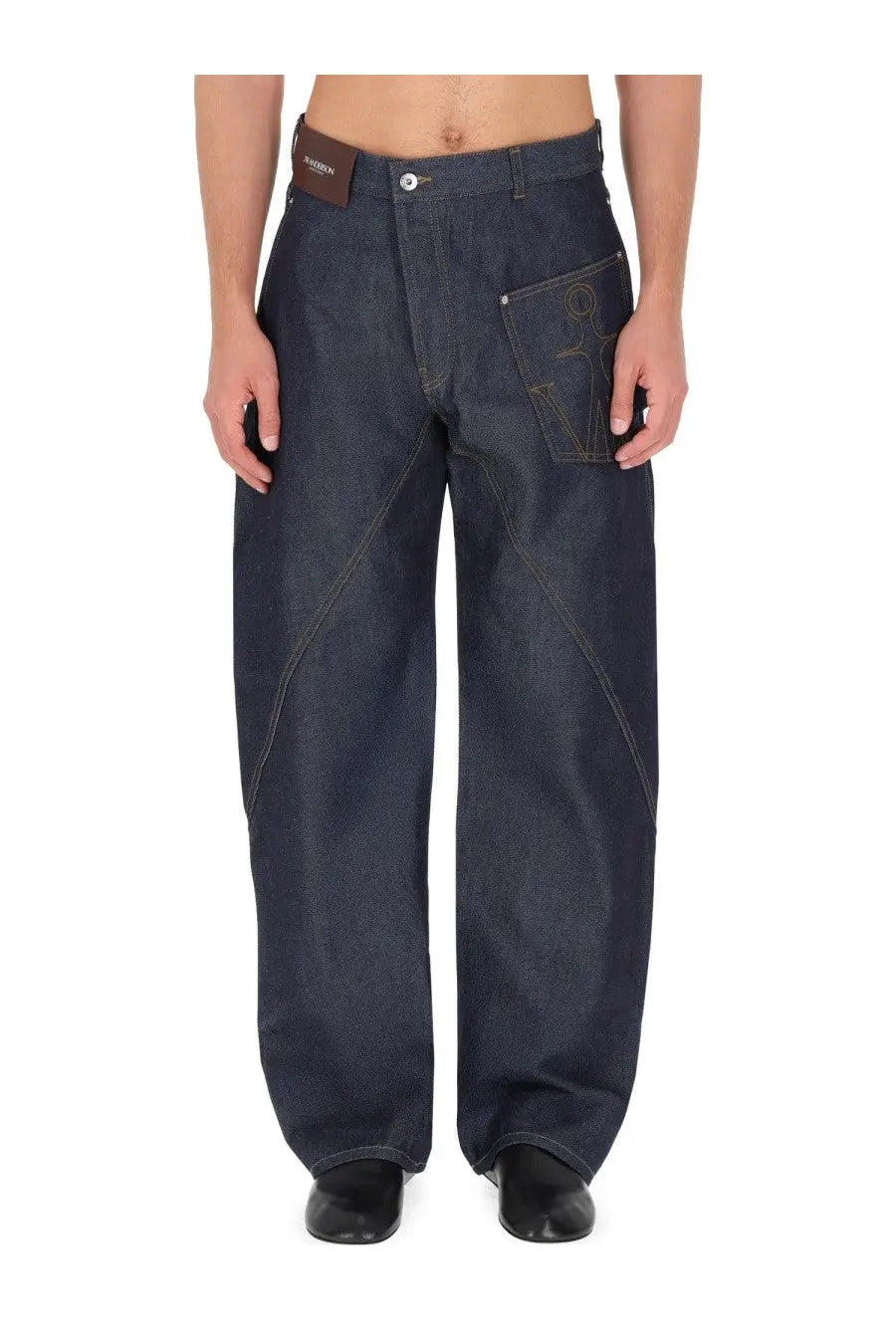 Jw Anderson men’s blue denim twisted workwear jeans with distinctive front pocket stitching and brown leather waistband tag