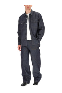 Jw anderson men’s twisted workwear jeans blue paired with a dark indigo denim jacket with chest pockets and button closures