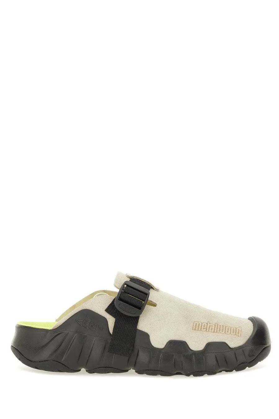 Beige suede keen men’s clog with black rubber sole and strap featuring textured design and metalwood branding