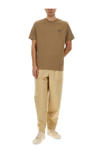 Tan short-sleeved t-shirt with embroidered fox logo paired with kenzo men’s beige cargo jogging pants