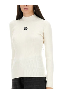 Kenzo women’s jersey white cream ribbed knit turtleneck sweater with black floral embellishment on the chest