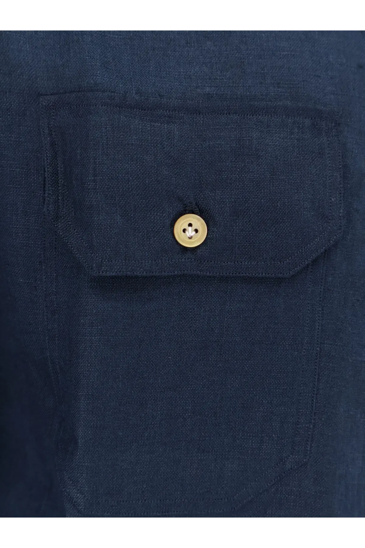 A gold-toned button with four holes on the flap of a dark blue linen pocket of a kiton men’s linen shirt blue