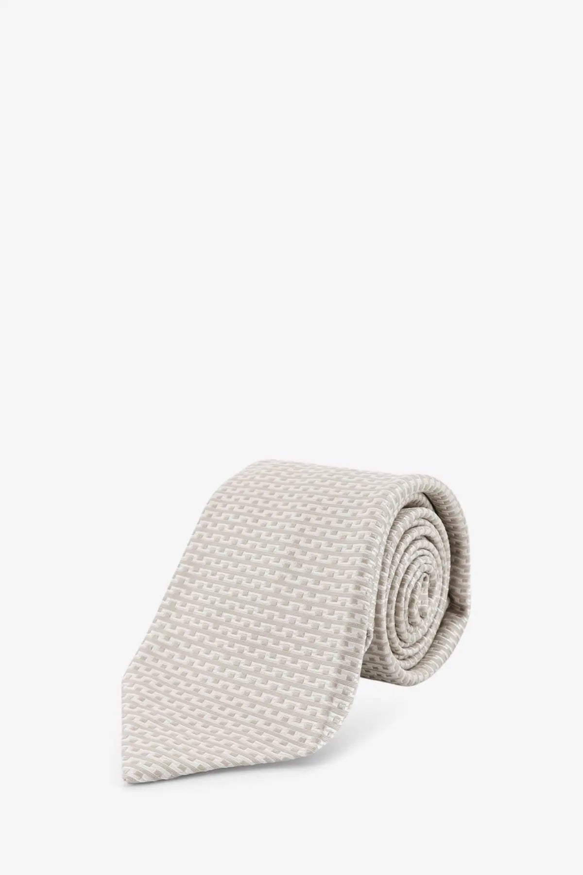 A neatly rolled kiton men’s silk tie in beige with a subtle woven texture and multicolor accents