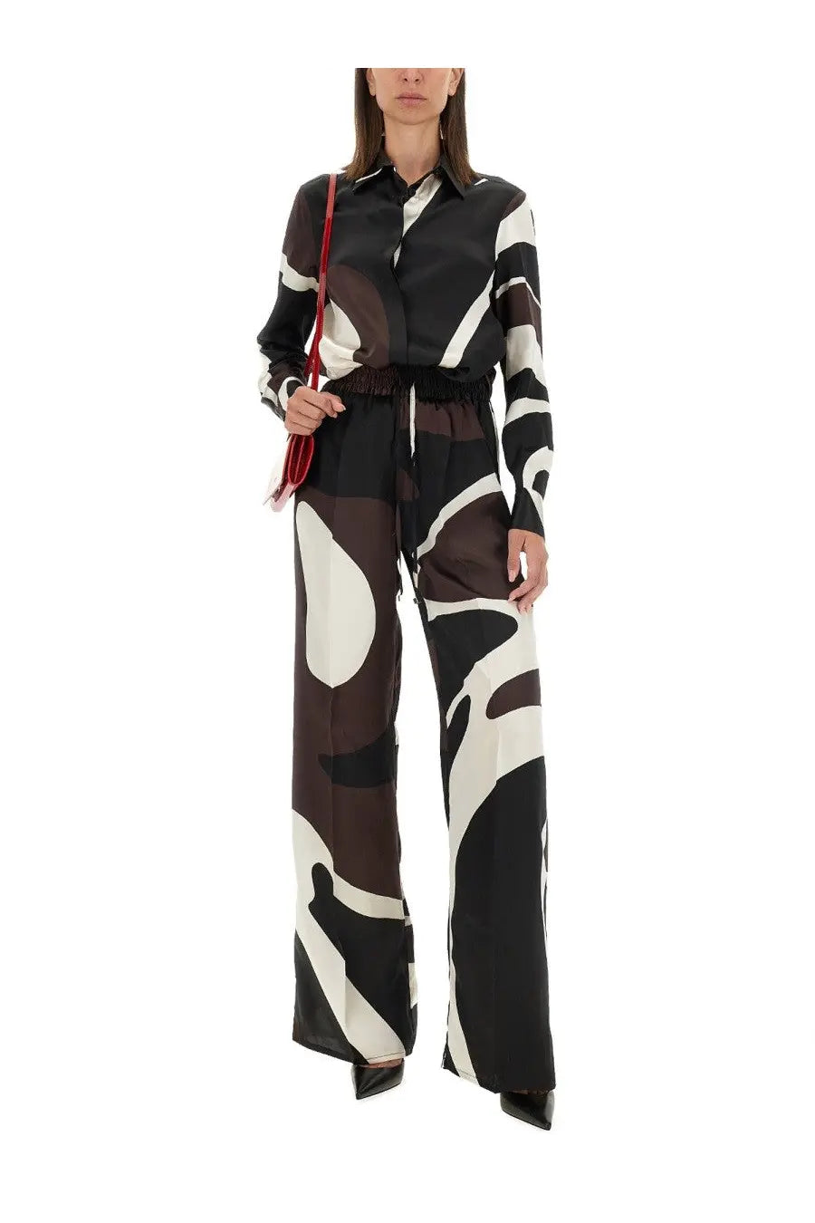 Kiton women’s printed shirt brown paired with a black and white abstract-patterned silk jumpsuit with fitted top and wide legs
