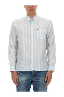 Lacoste men’s shirt in light blue and white vertical stripes with long sleeves and green crocodile logo on chest pocket