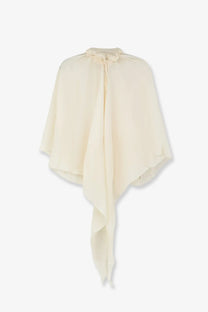 Cream-colored silk cape with draped asymmetrical hem and tied neckline in lamrons women’s modal and silk blend top white